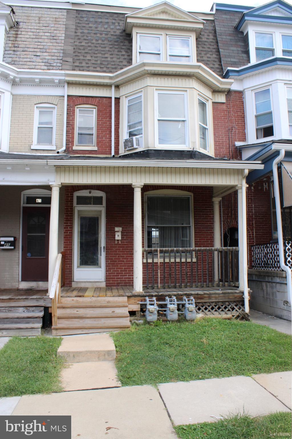 front view of a brick house with a yard