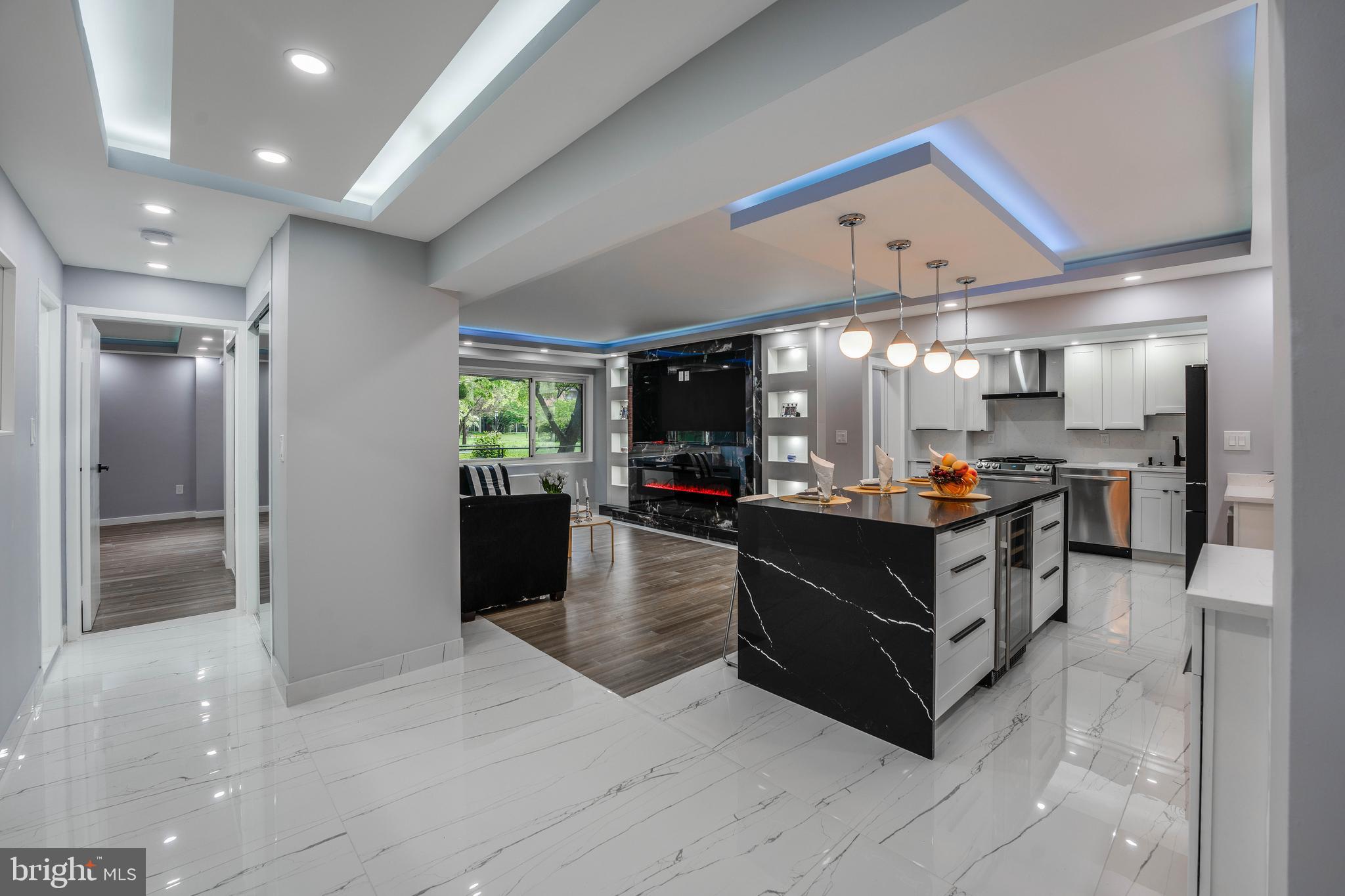 a living room with stainless steel appliances kitchen island granite countertop a refrigerator and a view of living room