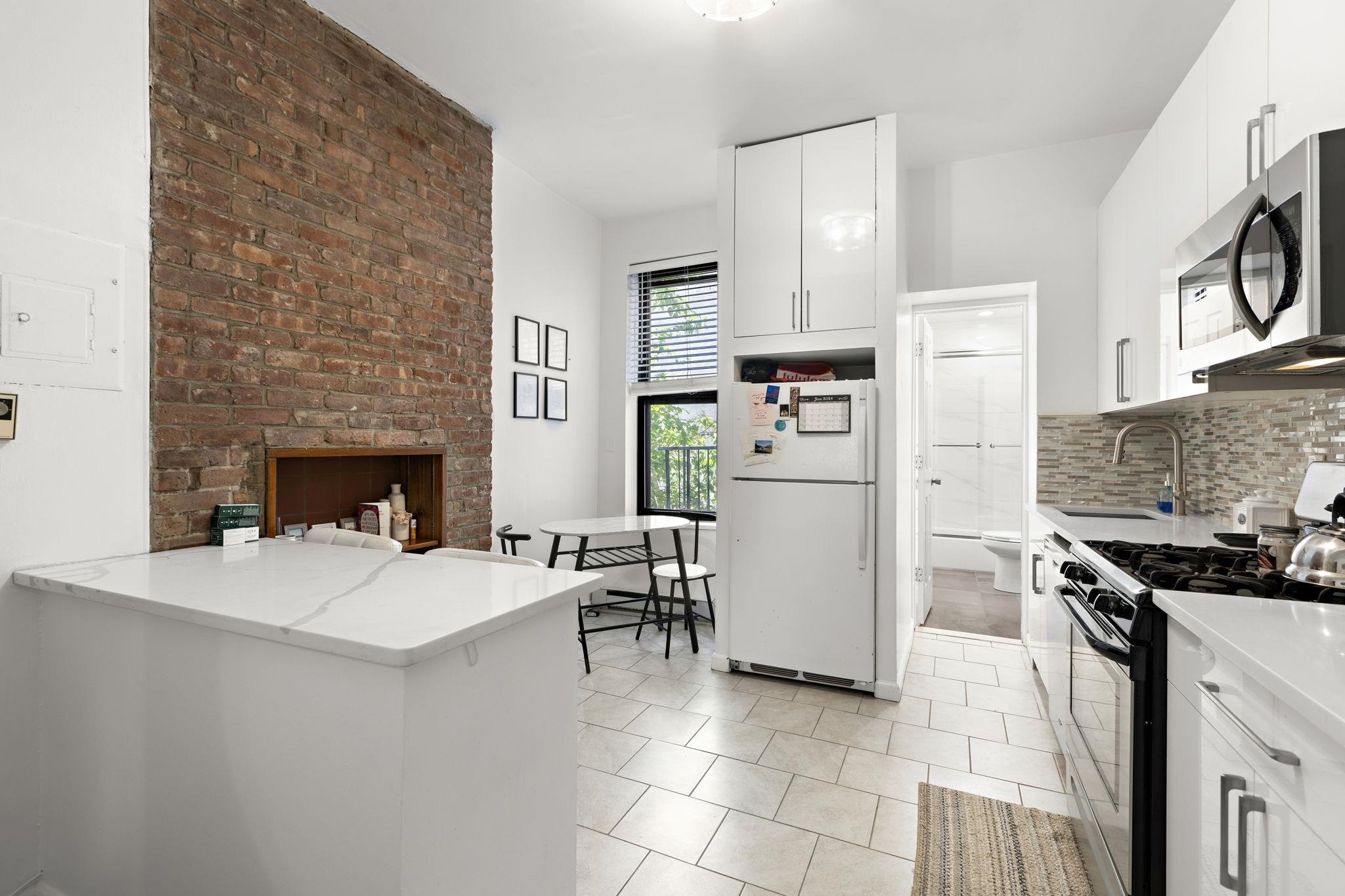 a kitchen with a refrigerator and a stove top oven