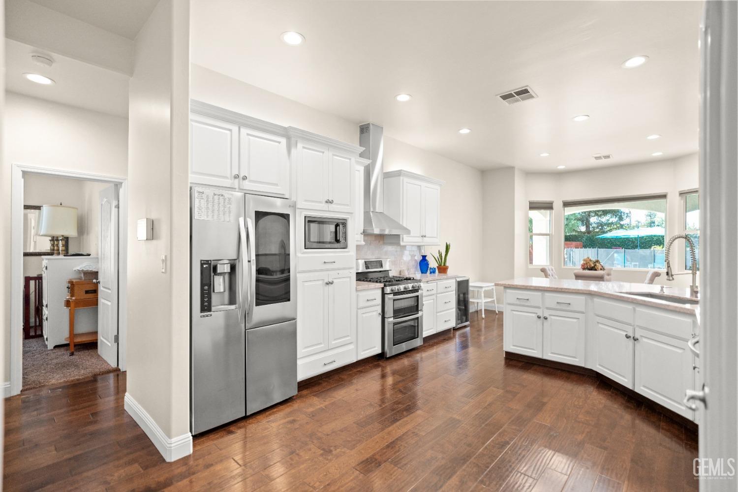 a kitchen with white cabinets and stainless steel appliances