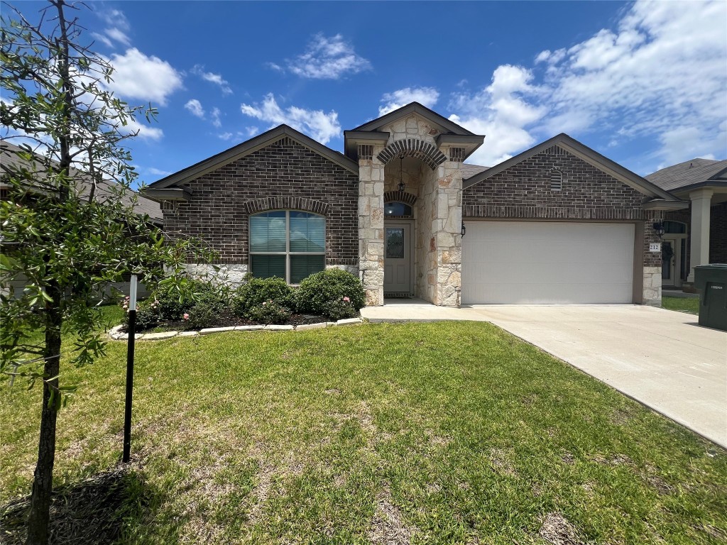 a front view of a house with a yard and garage