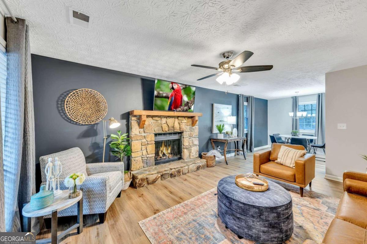 a living room with furniture a fireplace and a chandelier