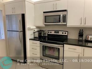 a kitchen with stainless steel appliances granite countertop a refrigerator stove and microwave