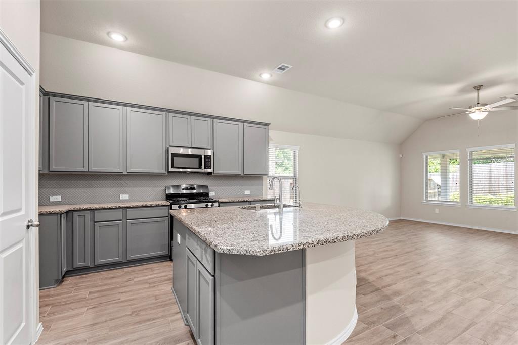 a kitchen with stainless steel appliances granite countertop a sink stove and refrigerator