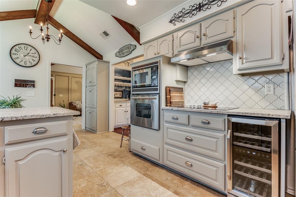 a kitchen with stainless steel appliances granite countertop white cabinets and window