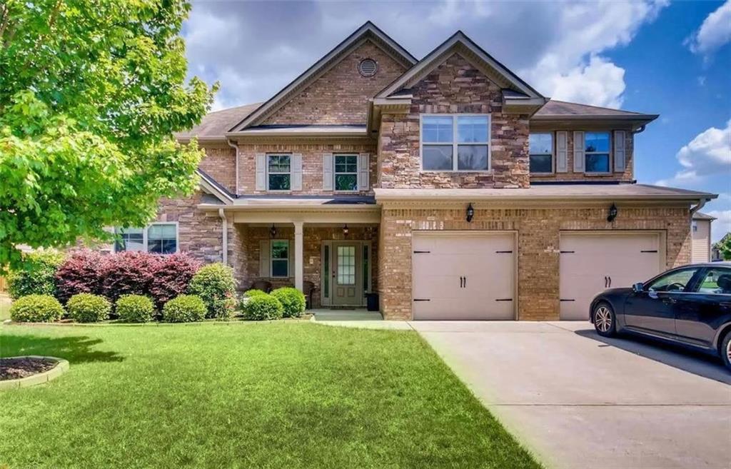 a front view of a house with a yard and garage