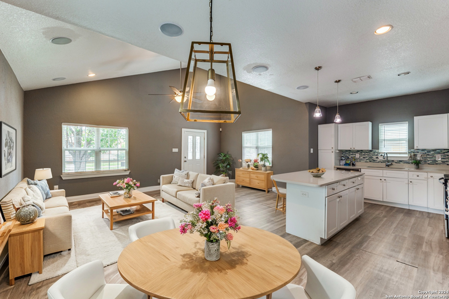 a living room with kitchen island furniture and a chandelier