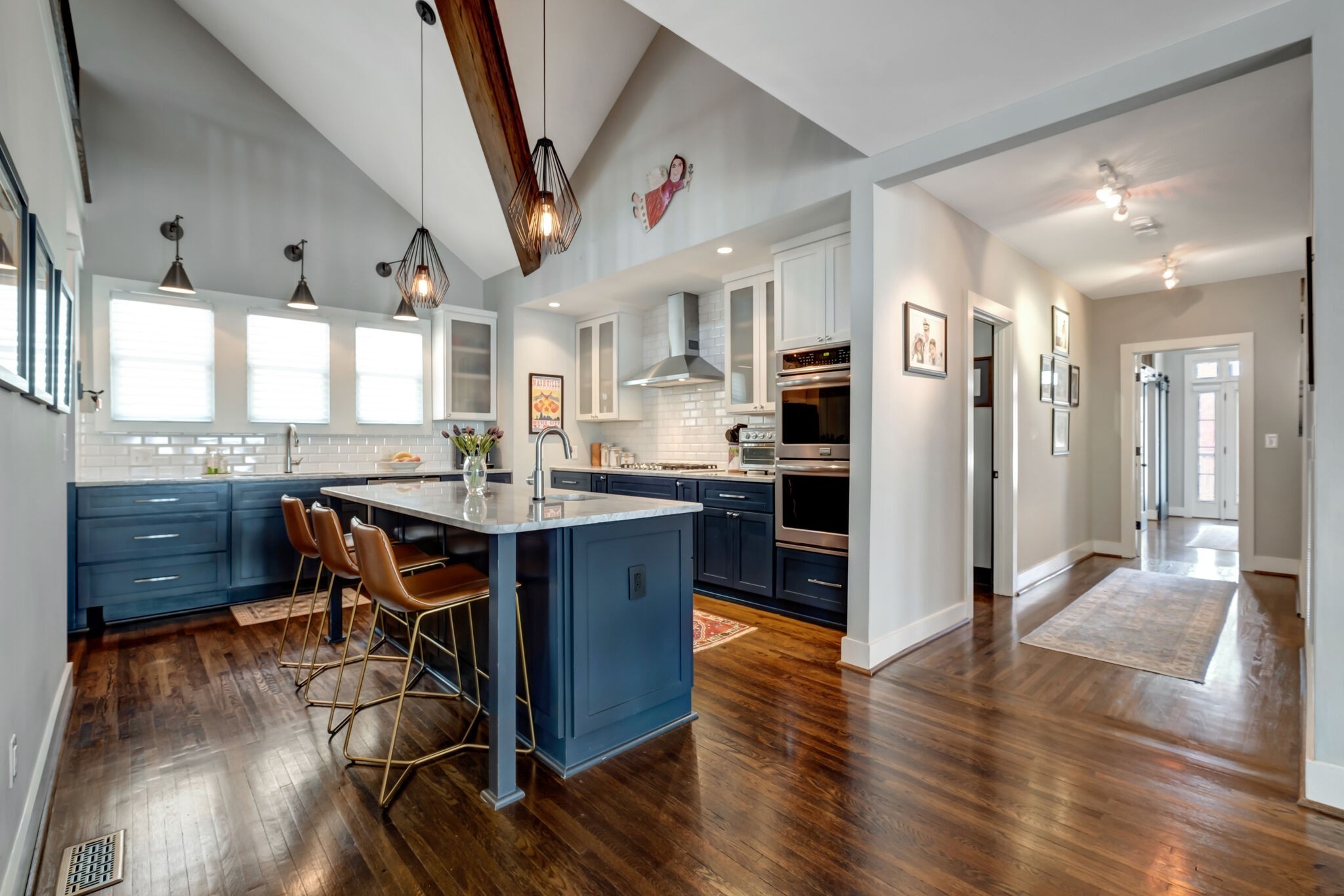 a kitchen with stainless steel appliances kitchen island granite countertop a table chairs sink and cabinets