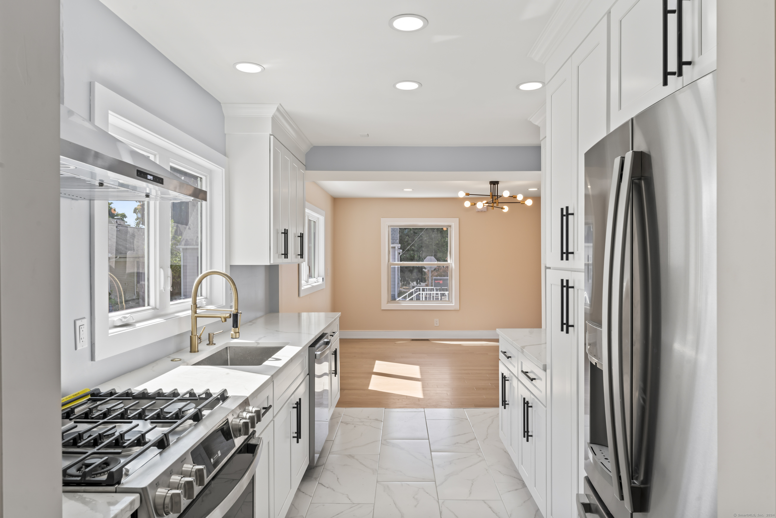 a kitchen with stainless steel appliances granite countertop a sink stove and refrigerator