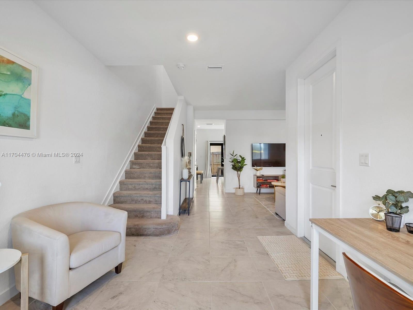 a living room with furniture and a dining table with kitchen view