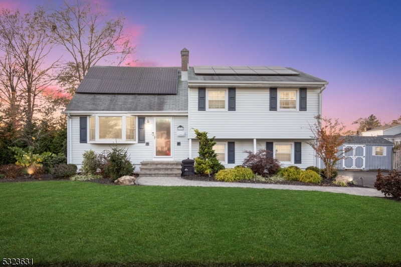 a front view of a house with a garden and plants