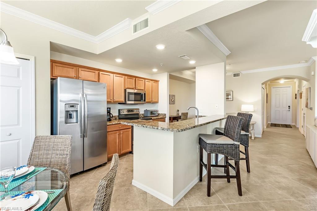 a kitchen with refrigerator and chairs