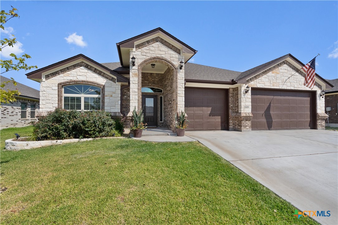 a front view of a house with a yard and garage