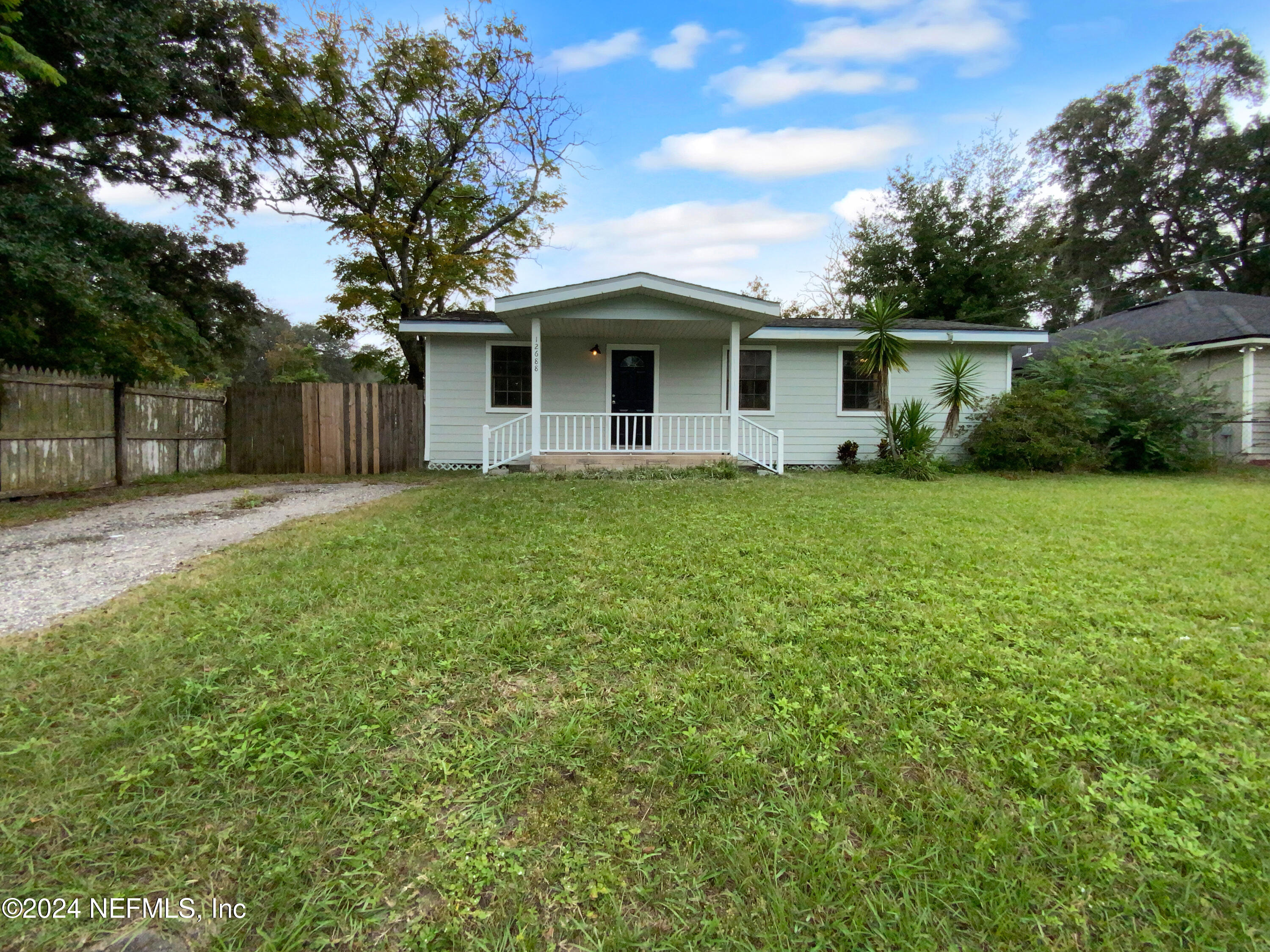 a front view of a house with yard and tree