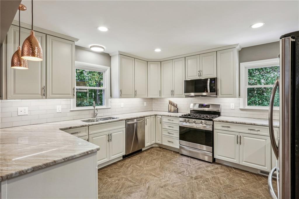 a kitchen with a sink stove top oven and refrigerator