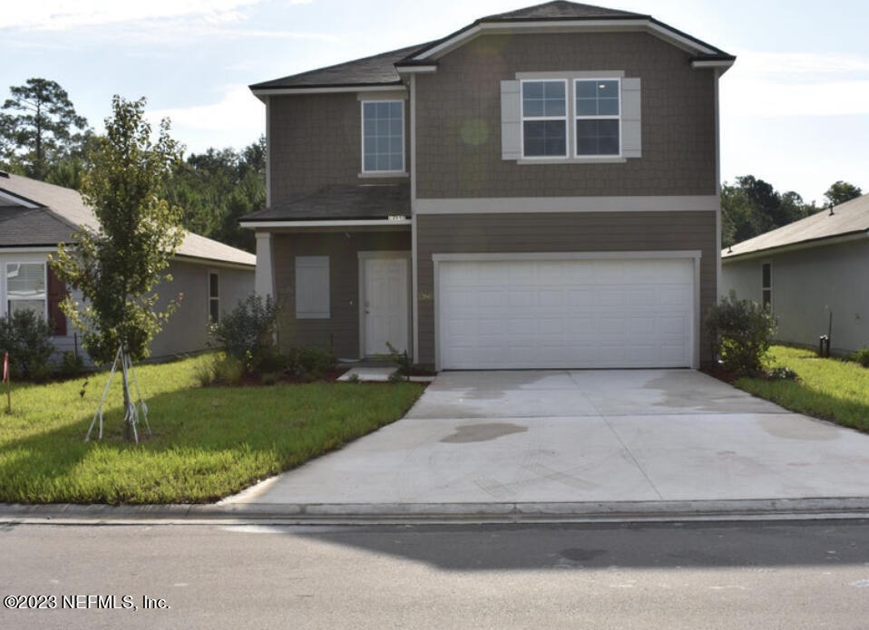 a front view of a house with a yard and garage