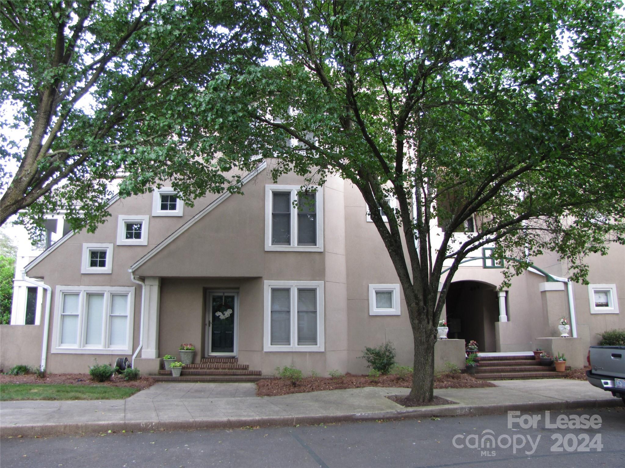 a front view of a house with a tree