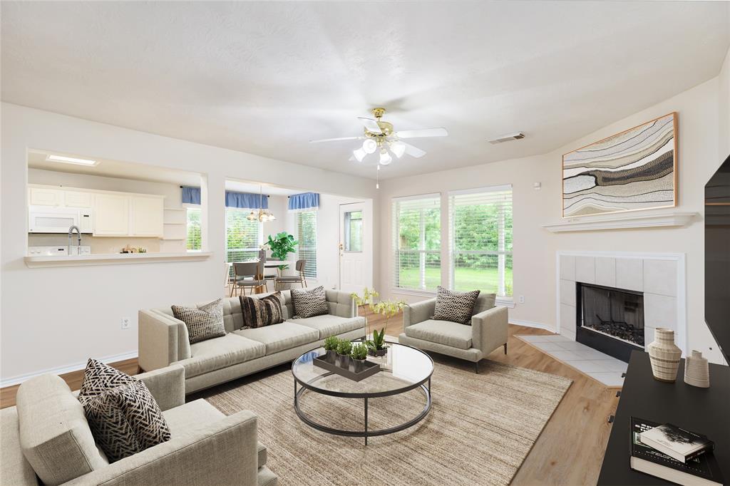 a living room with furniture a fireplace and a large window