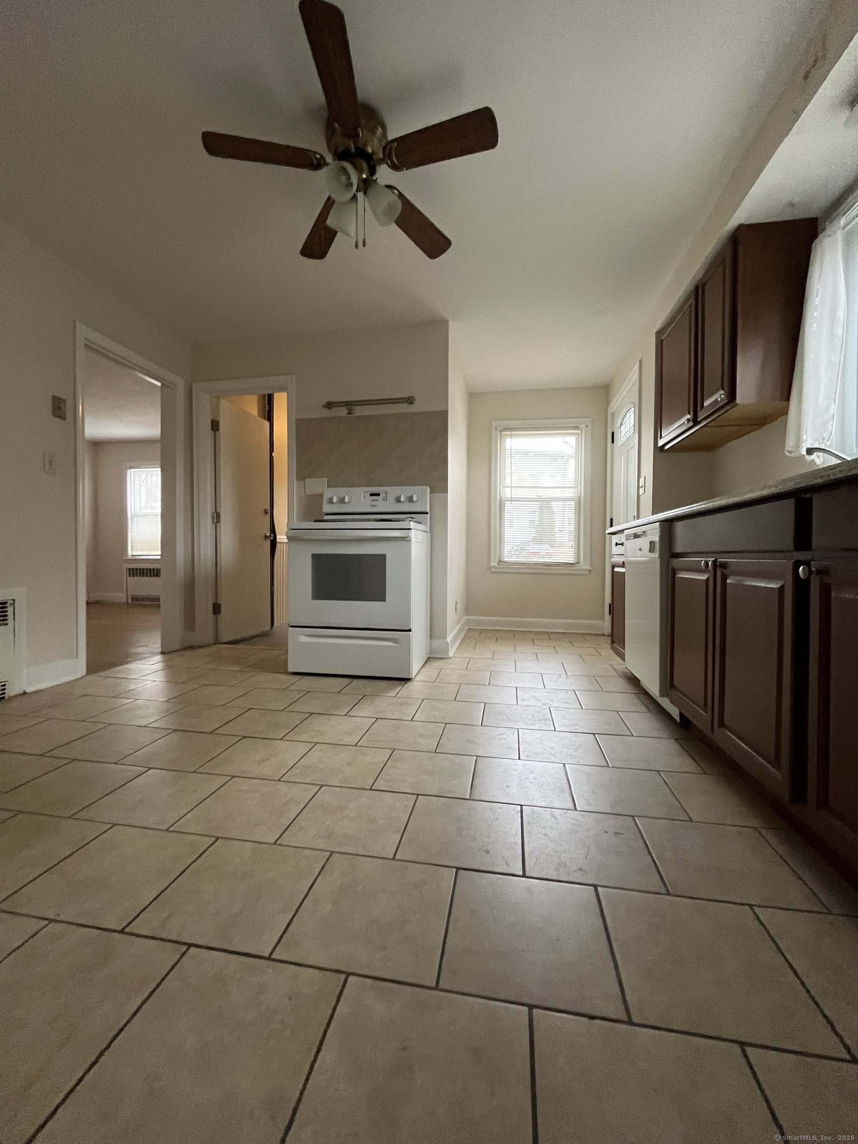 a kitchen with granite countertop a stove a sink and a refrigerator