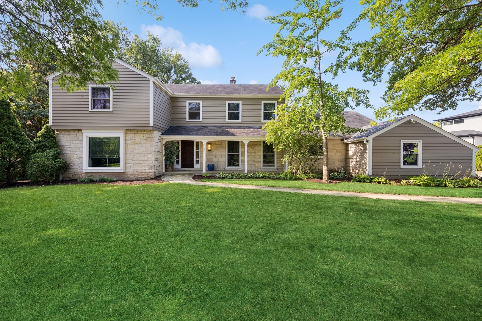 a front view of house with yard and green space