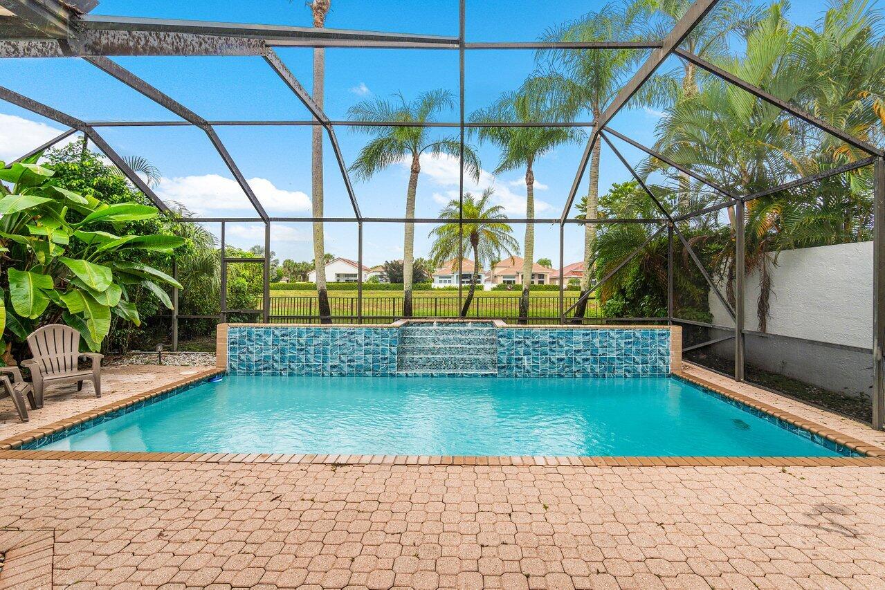 a view of a swimming pool with a bench and trees