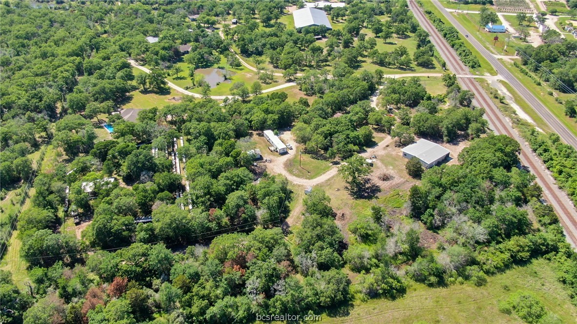 an aerial view of residential houses with outdoor space and trees