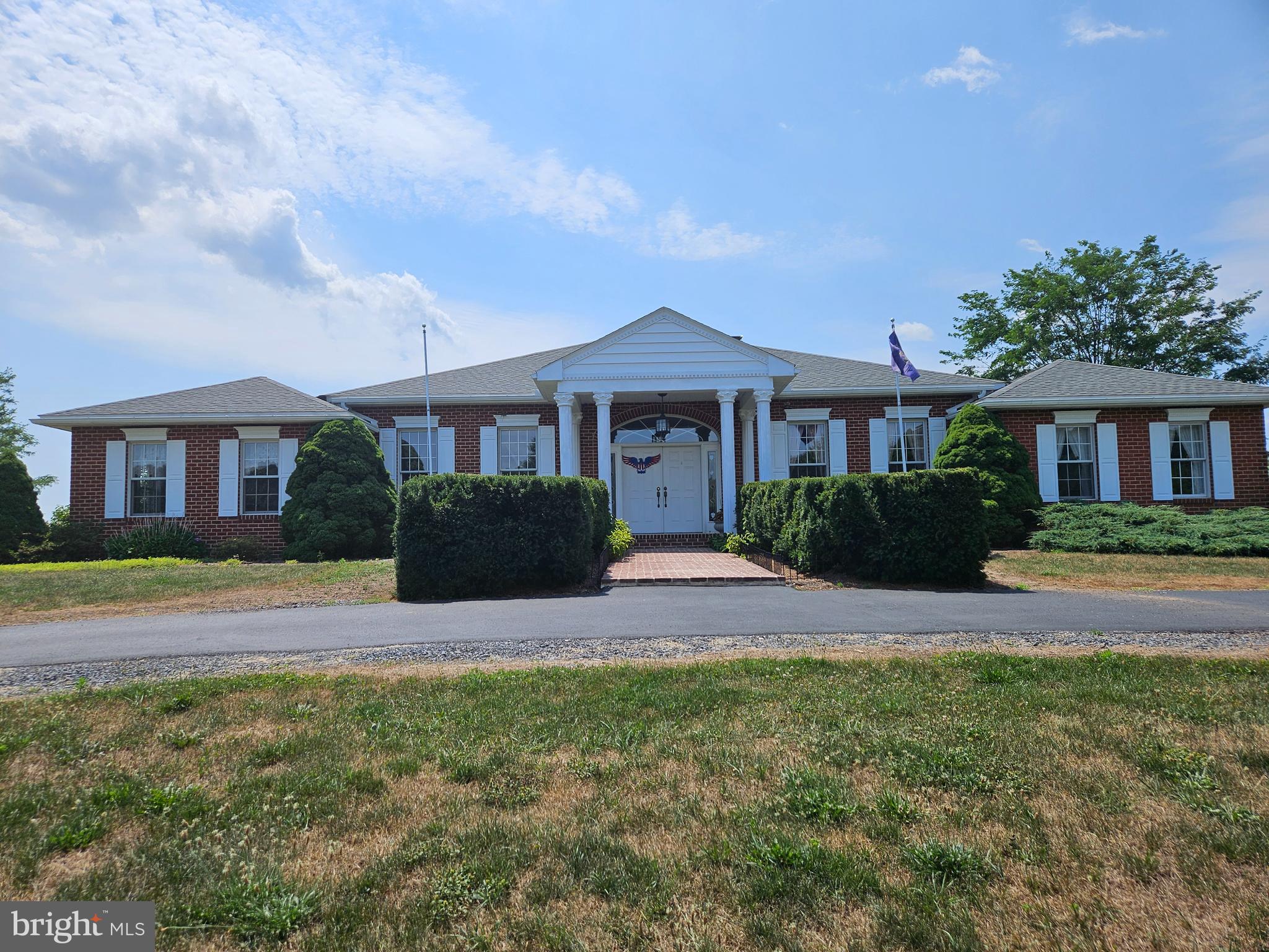 a front view of a house with yard and green space