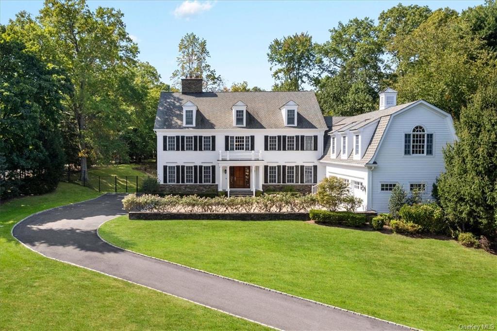 a front view of a house with a garden and trees