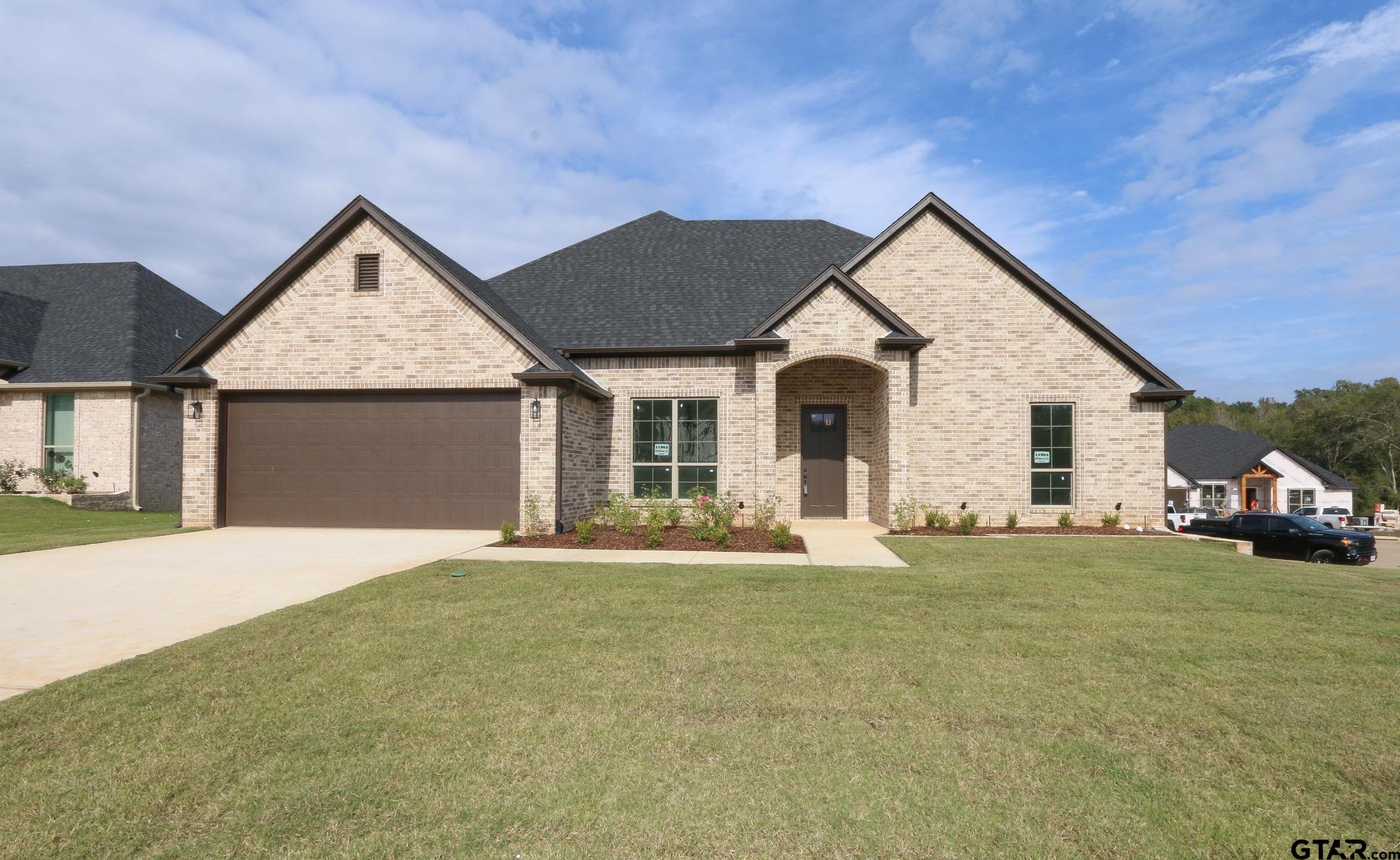 a view of a house with yard and garage