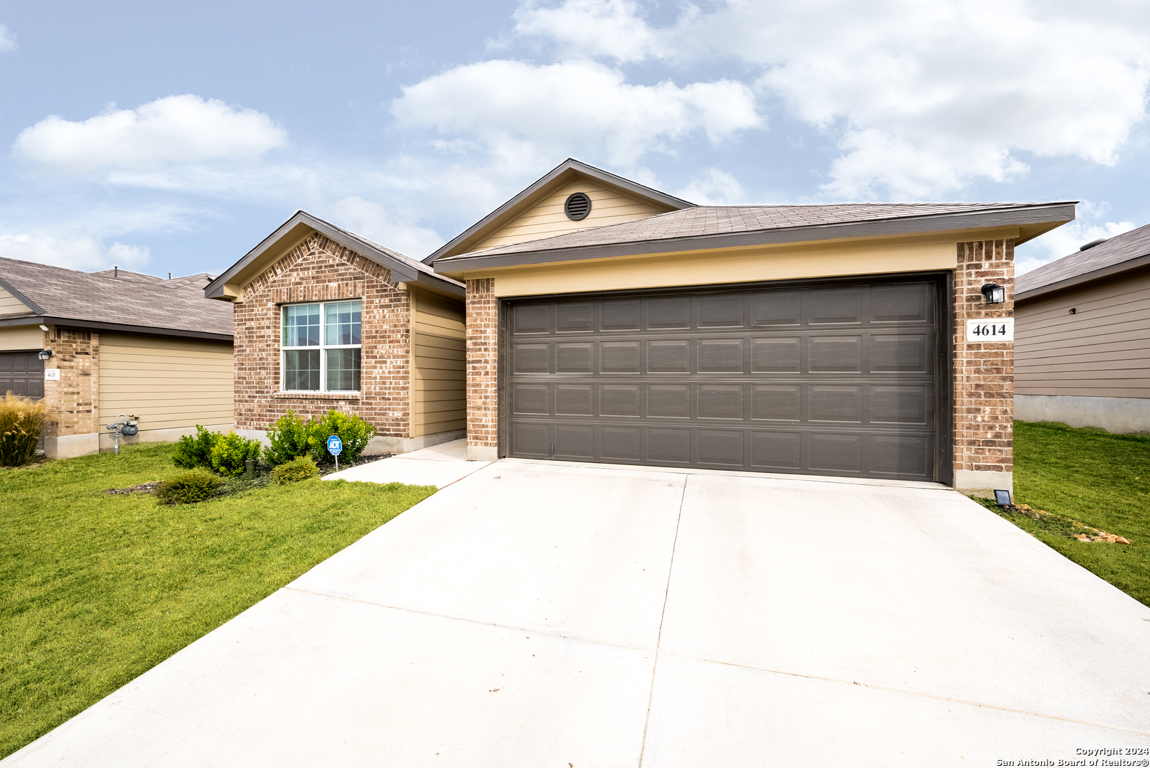 a front view of a house with a yard and garage