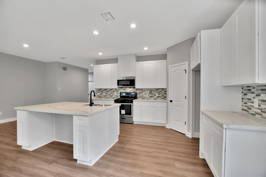 a kitchen with white cabinets and white appliances