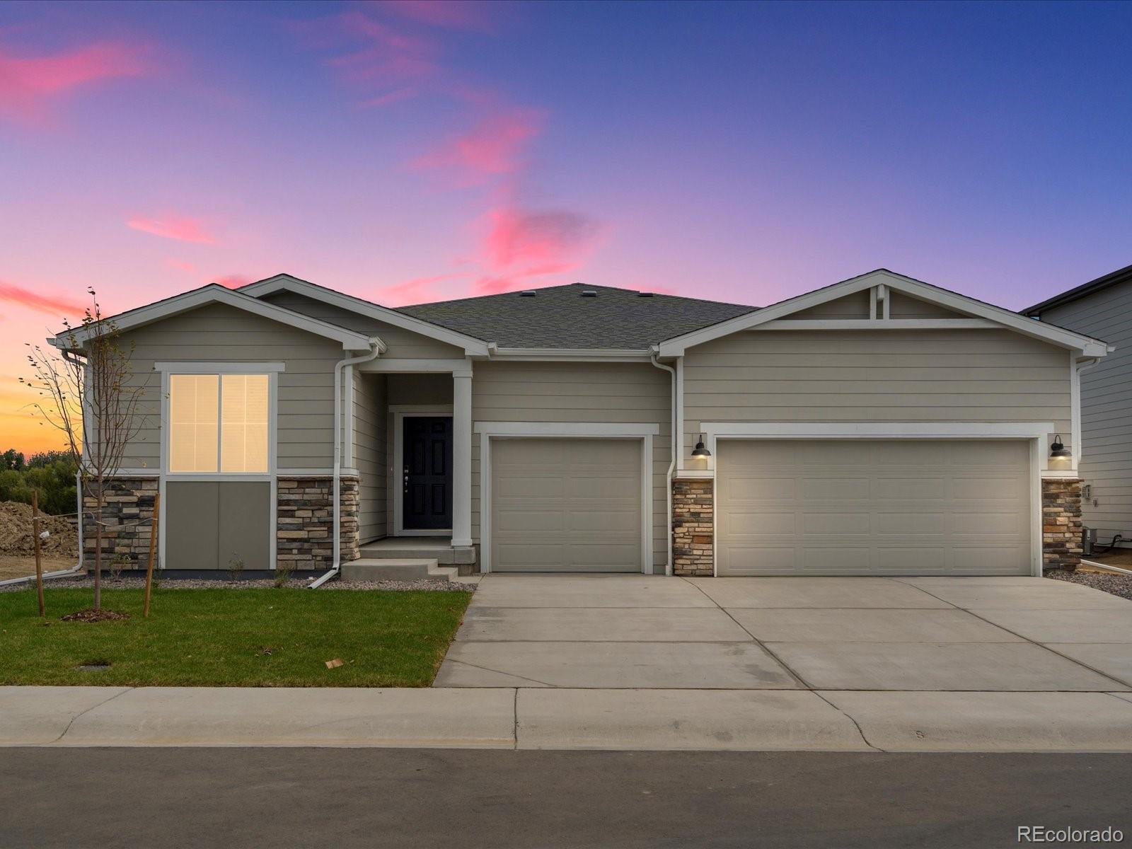 a front view of a house with a garden and garage