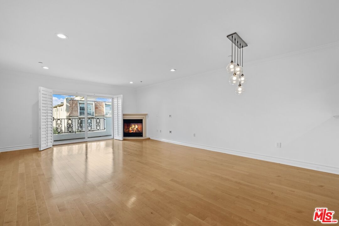 a view of an empty room with a fireplace and a window