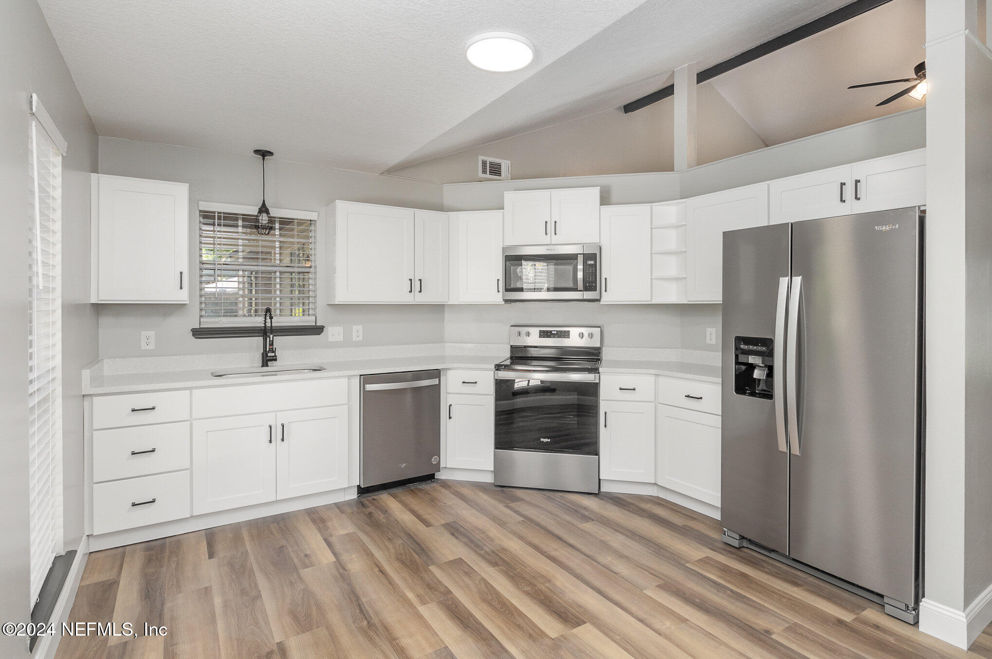 a kitchen with stainless steel appliances a refrigerator sink and microwave