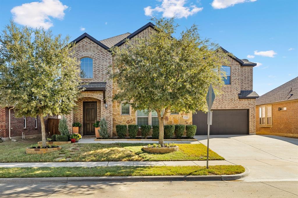 View of front of house featuring a front lawn and a garage