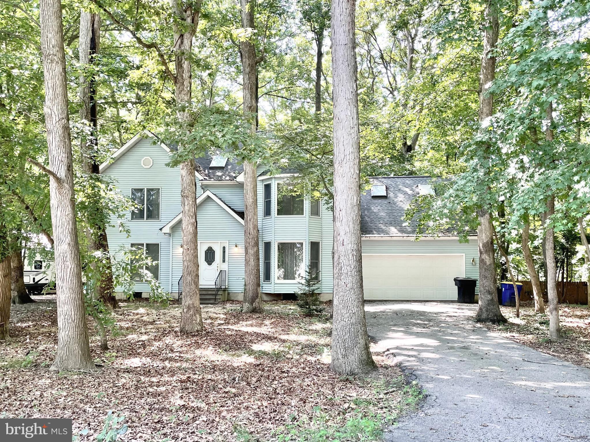 a front view of a house with a tree in front