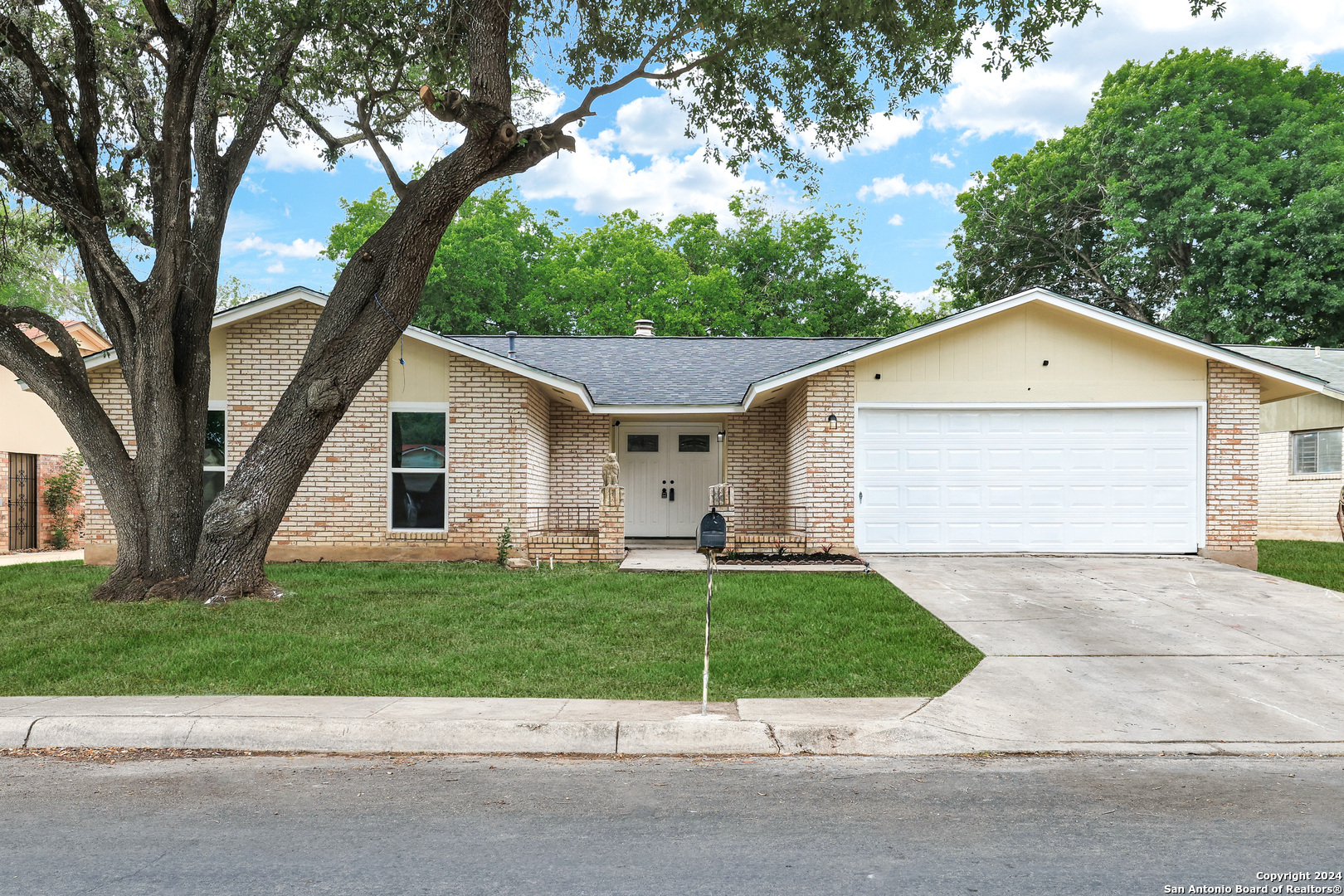 a front view of a house with a yard and garage