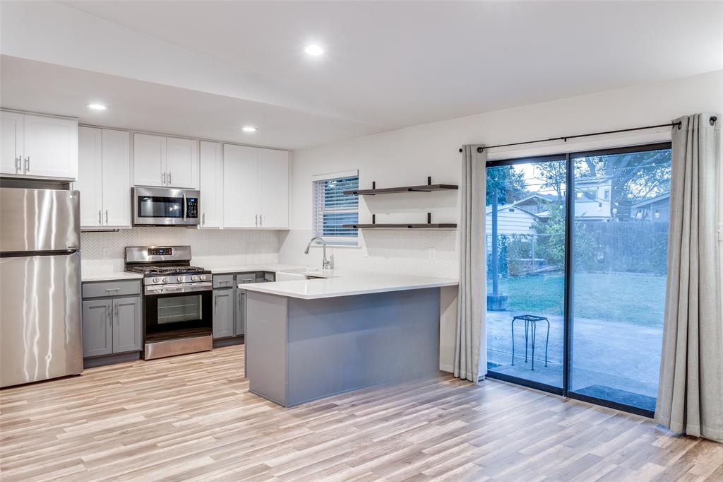 a kitchen with stainless steel appliances granite countertop a refrigerator stove and sink