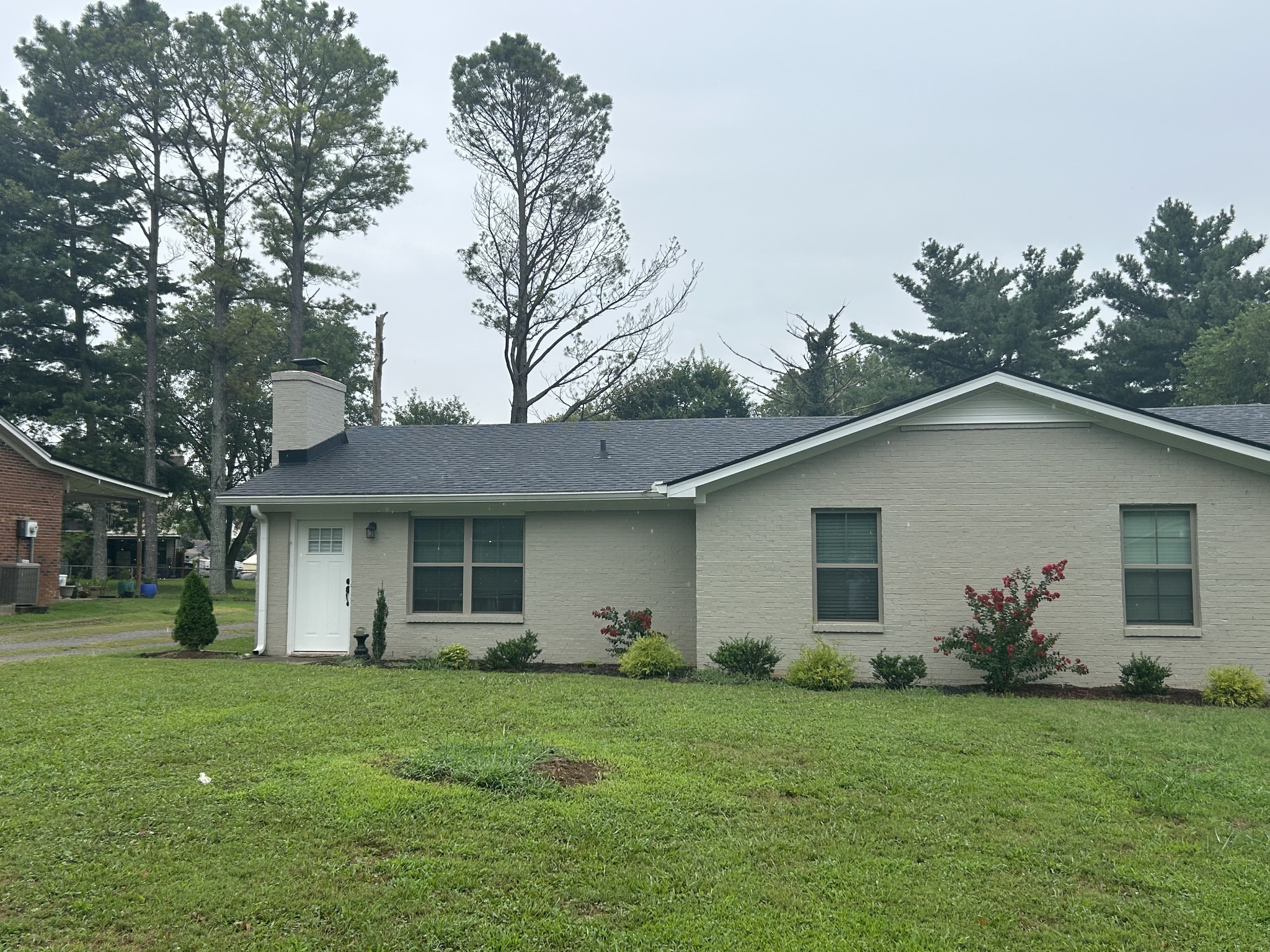 a view of a house with a yard and potted plants