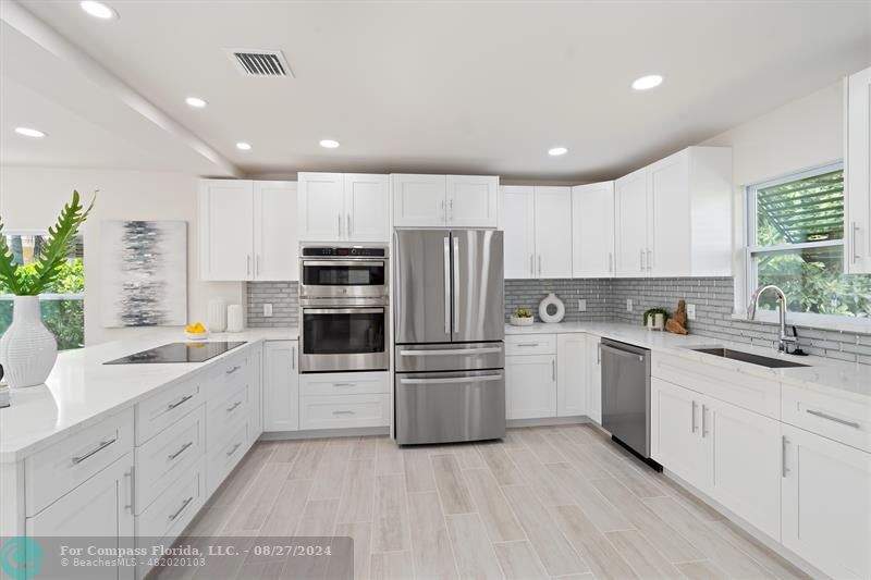 a kitchen with white cabinets and stainless steel appliances