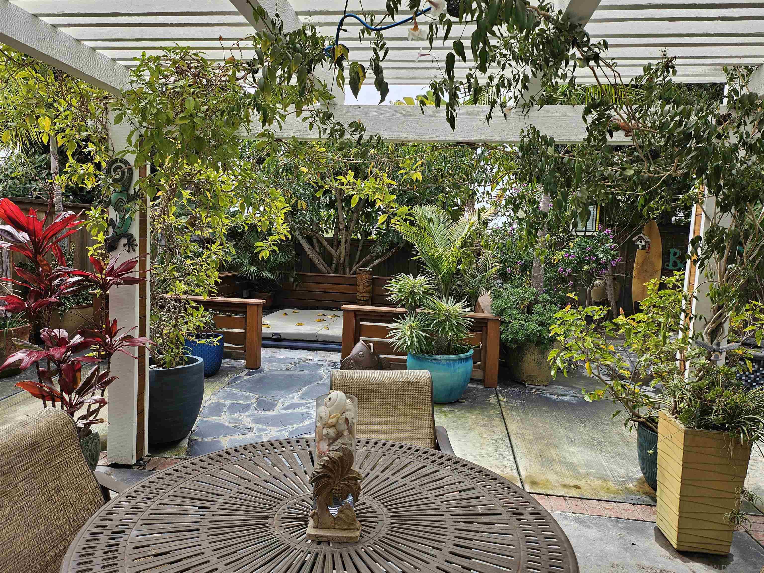 a view of a patio with couches and table and chairs and potted plants