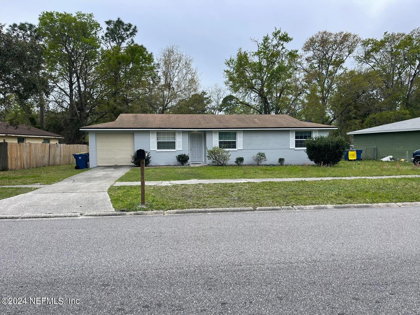 a view of a house with a big yard and large trees