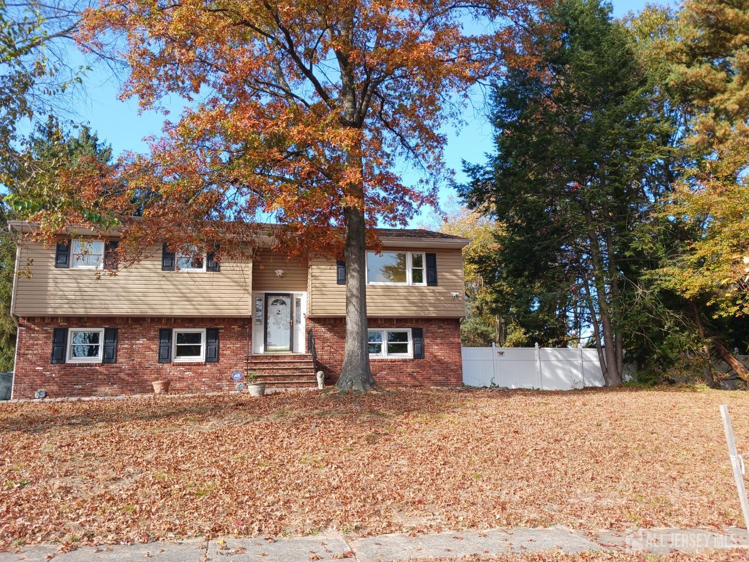 a front view of a house with a tree