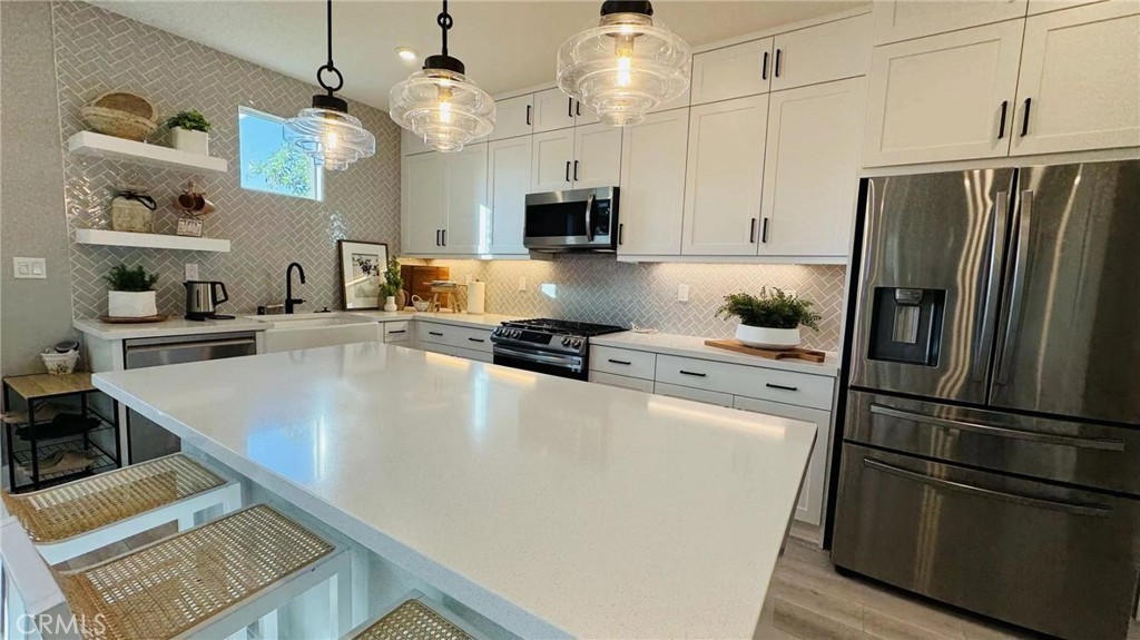 a kitchen with kitchen island a counter top space stainless steel appliances and cabinets