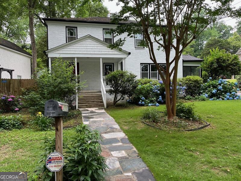 a front view of a house with a yard and potted plants