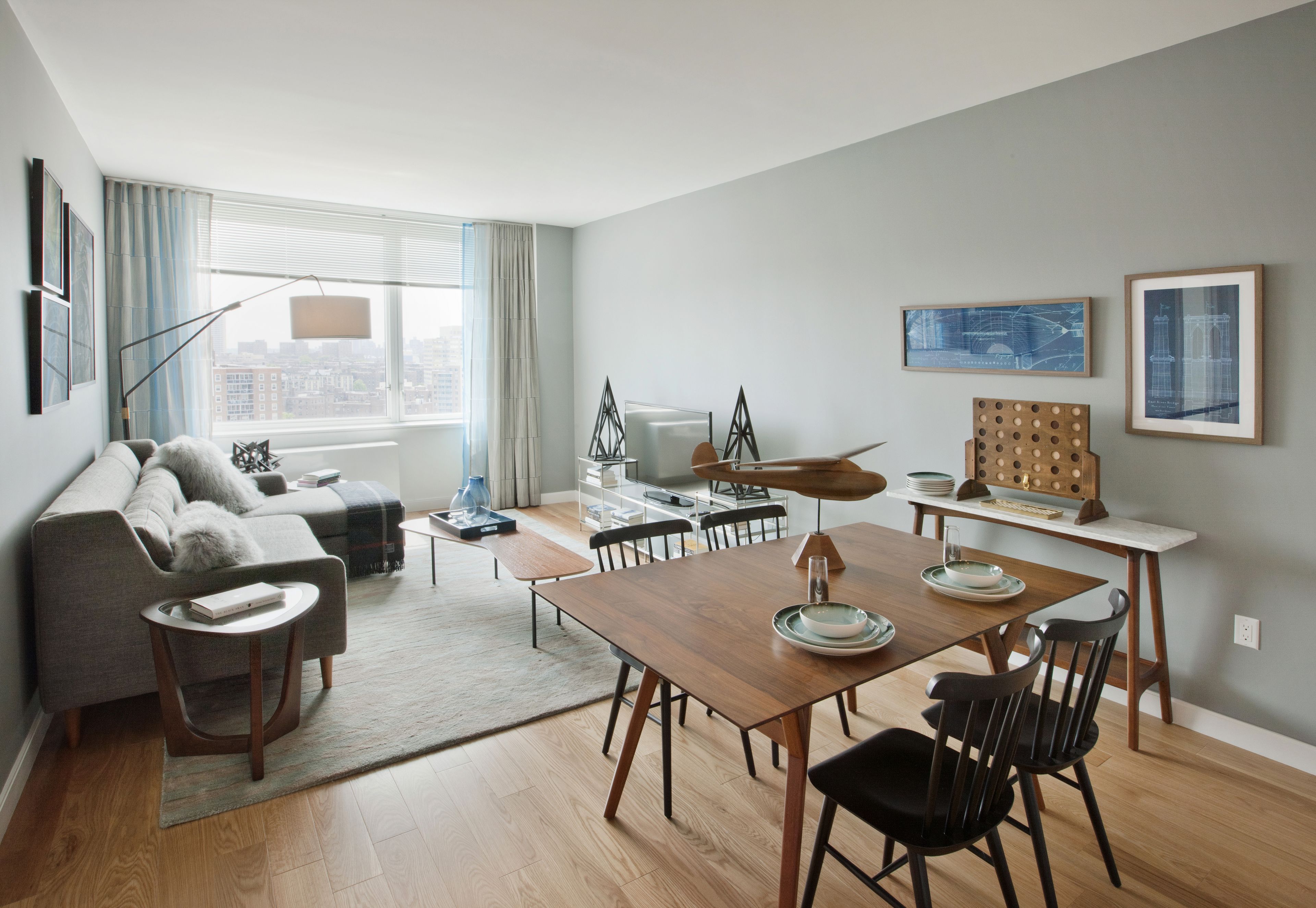 a view of a dining room and livingroom with furniture wooden floor a rug and a potted plant