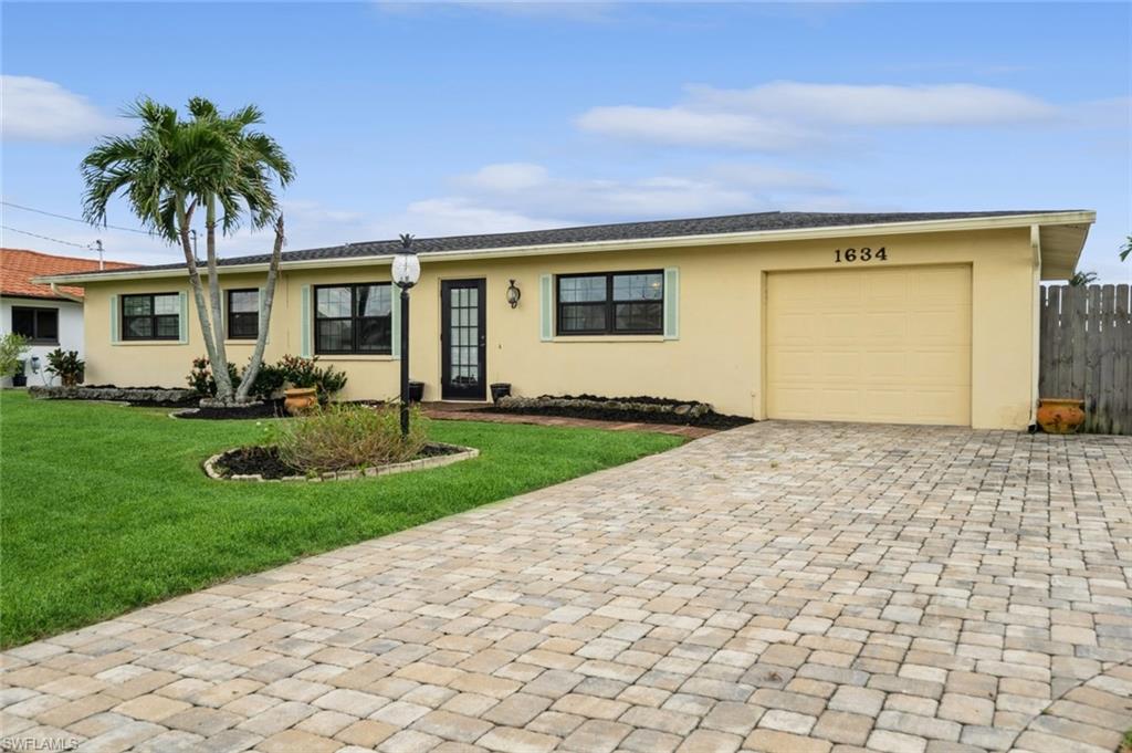 a front view of a house with a garden and yard