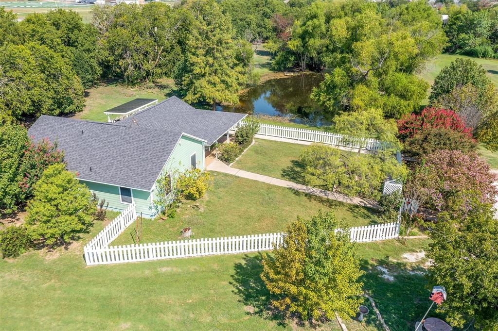 an aerial view of residential house with outdoor space and trees all around