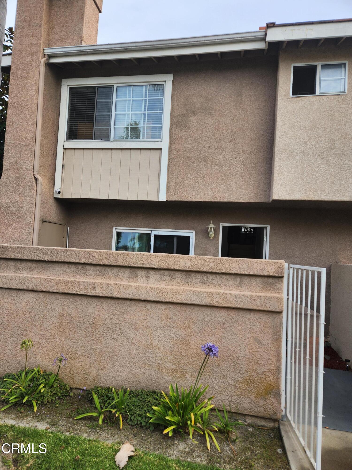 a front view of a house with plants