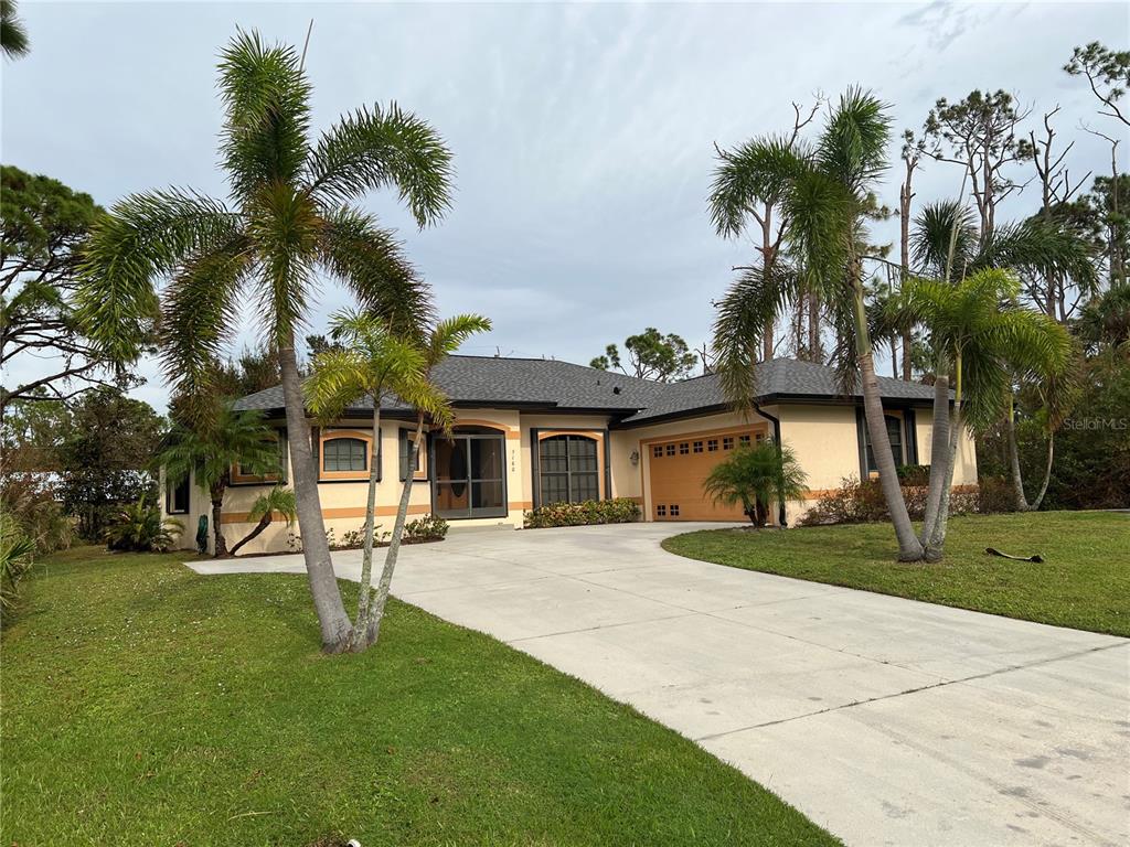 a front view of a house with a yard and palm trees